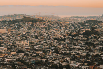 Beautiful city of San Francisco during sunset with a view of the bay area that has ships. This is a view from the Twin Peaks mountain