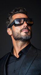 Fototapeta premium A man in a suit and sunglasses looking up at the sky