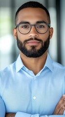 Fototapeta premium A man with a beard and glasses standing with his arms crossed