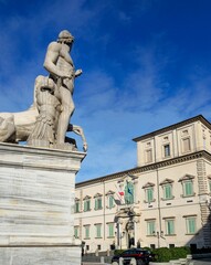 Obraz premium Marble statue of Castor with a horse in Piazza del Quirinale, Rome, with the Quirinal Palace in the background under a clear blue sky. Rome, Italy - December 25, 2024