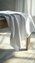 White tablecloth on a wooden table in sunlit kitchen.