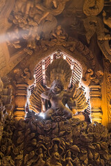 Buddhist tantric deity riding a lion, wood carving at Sanctuary of Truth, Pattaya, Thailand .
