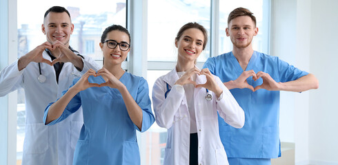 Team of doctors making hearts with their hands in clinic