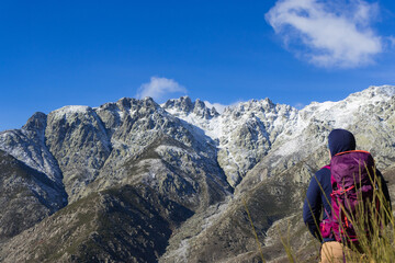 Fototapeta premium Mountaineer looking at the Sierra de Gredos with snow, southern part, travel ads and postcards, unusual views of the area.
