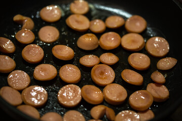 fried sausage pieces in a frying pan
