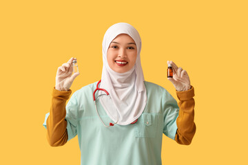 Female Muslim doctor in hijab with stethoscope and ampules on orange background. World Hijab Day concept