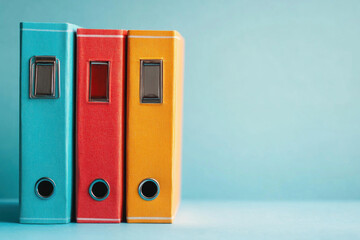 Three colored binders, black and red among them.