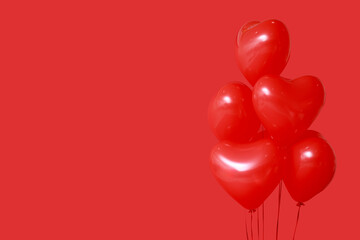 Beautiful heart-shaped balloons for Valentine's Day celebration on red background, closeup