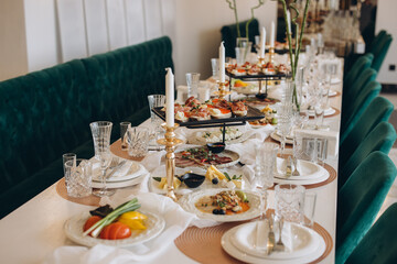 Elegant wedding table setting with delicious appetizers and golden candlesticks