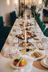 Elegant wedding table setting with appetizers, candles and lucky bamboo