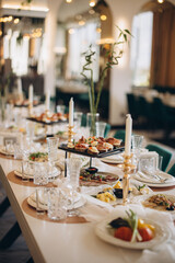 Elegant wedding table setting with appetizers, candles and flowers