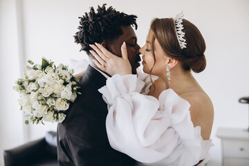 Interracial Couple Exchanging a Kiss on Wedding Day
