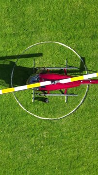 helicopter parked green grass field helipad shadow against vibrant landscape aviation top down birdseye aerial shot view upwards heliport london scenic travel 