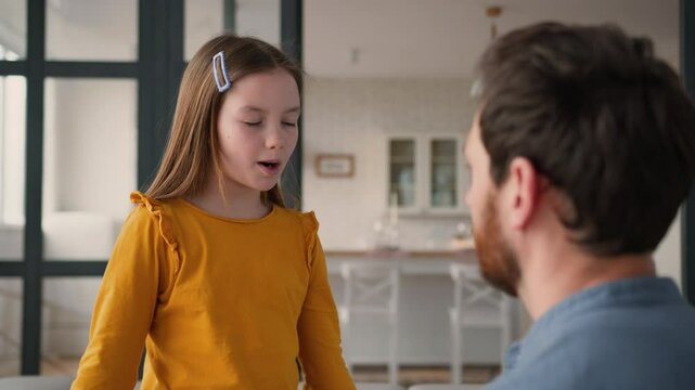 Caring Caucasian adult man father guy dad touching calm down glad preteen girl schoolgirl child at home childcare little daughter smile kid speaking parent male showing love family discussion bonding