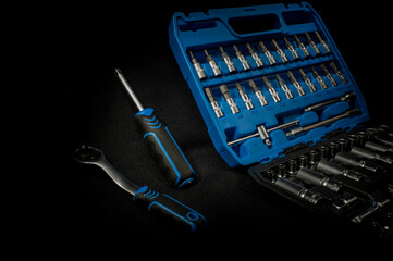 Car chrome silver tool kit with socket wrench on a dark background.