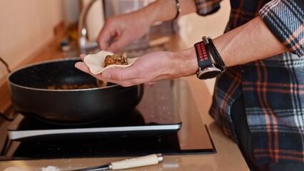 Person preparing homemade Georgian khinkali in a cozy kitchen setting