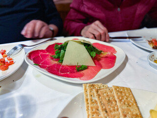 Beef carpaccio with arugula, parmesan cheese.