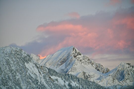 Snowcapped mountains under pink sky by sunset