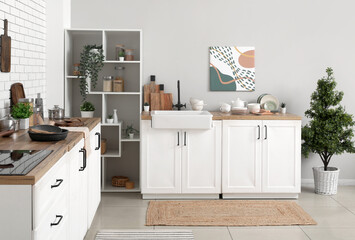 Kitchen counters with utensils and shelving unit in interior of kitchen