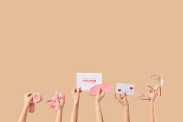 Female hands with sex toys, high heel, letter and card on beige background. Valentine's Day celebration