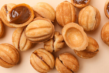 Sweet walnut shaped cookies with boiled condensed milk on beige background