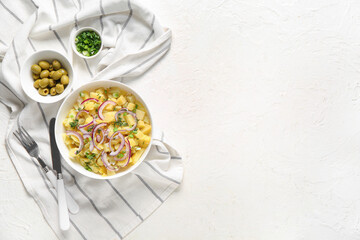 Bowl of tasty potato salad with onion and olives on white background