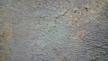 Aged and weathered white wall with multiple cracks and fractures, distressed surface texture background for design and architecture
