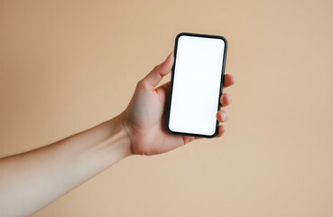 Hand holds smartphone with blank white screen against light beige background. Modern digital device displayed. Person shows mobile phone. Focus on technology, innovation in design, tech industry.