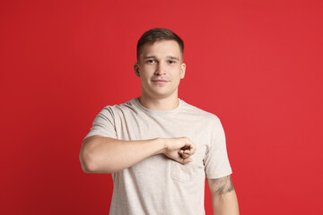Man making promise on red background. Oath gesture