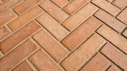 An upclose look at the intersection of two herringbone tiles revealing the precise angles and the subtle variations in the terracotta textures.