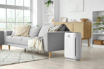 Air purifier near sofa in light living room