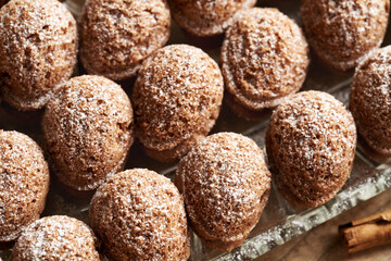 Baked homemade Christmas cookies in the form of nuts filled with cream and dusted with sugar