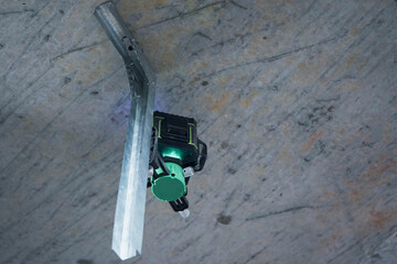 A close-up of a laser level that creates a clear horizontal line on the ceiling for precise measurements.