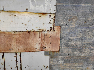A close-up of weathered, rusty metal sheets with peeling paint and visible textures, showcasing industrial decay and the passage of time, perfect for background.