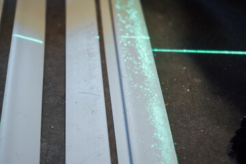 Two bright green laser beams appear one over the other on the floor, ensuring flawless accuracy in the construction process.