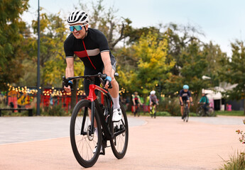 Fototapeta premium Group of athletic people riding bicycles outdoors, space for text