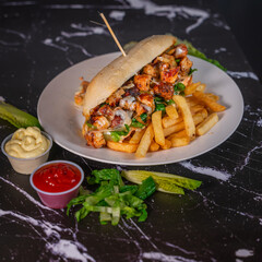 Chicken Fajita Sandwich with French Fries and Sauces on a Marble Table


