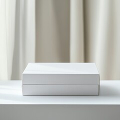 Two blank white boxes on a white surface against a neutral curtain backdrop.