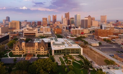 Obraz premium Columbus, OH skyline at dawn, showcasing urban development and construction. Modern buildings, historical architecture, and a park are visible. DOWNTOWN, COLUMBUS, OHIO, UNITED STATES