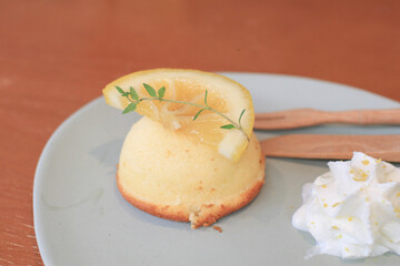 Lemon pound cake with fresh cream in plate on wooden table. Coffee shop dessert. Sweet holiday party.