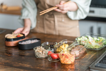 キッチンでお弁当を詰める女性の手元（愛妻弁当）
