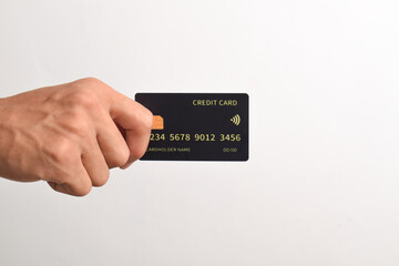 Hand holding black credit card isolated on white background.