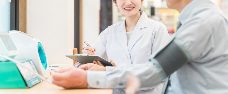 病院・クリニックで人間ドック・健康診断する男性と医師（血圧）
