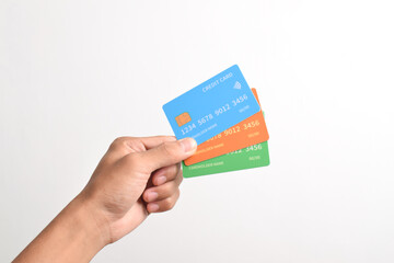 Hand is hold three credit cards. Blue, green and orange credit cards isolated on white background.