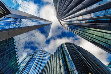 skyscraper buildings in business district, London City. Cloud on sunny day sky. Low angle view. Europe financial economy, merger and acquisition, or modern architecture concept, blue urban background