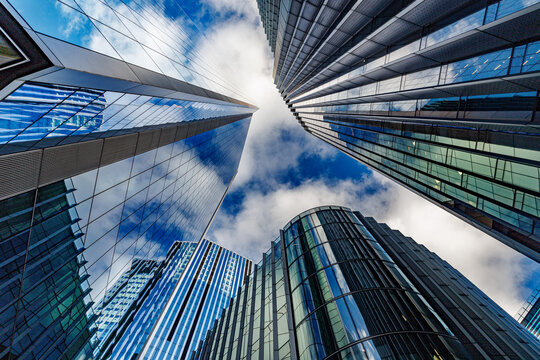 skyscraper buildings in business district, London City. Cloud on sunny day sky. Low angle view. Europe financial economy, merger and acquisition, or modern architecture concept, blue urban background