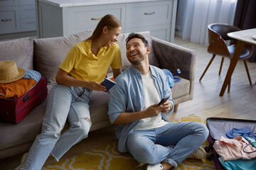 Joyful married couple booking hotel for vacation via mobile phone