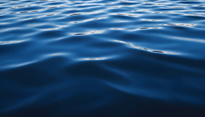 Dark blue abstract background. Reflection of light on a smooth surface of water with small waves.