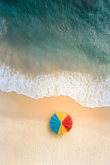 Obraz premium Solitary Colorful Beach Umbrella on Pristine Sandy Shores Under Clear Skies