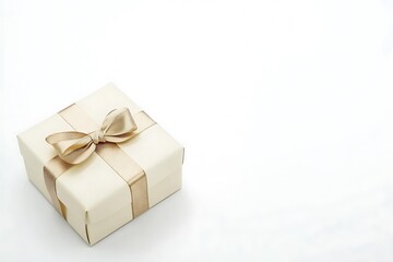 Obraz premium Cream gift box wrapped with a gold satin ribbon bow ideal for luxury gift presentation at celebrations or special events isolated on a white background